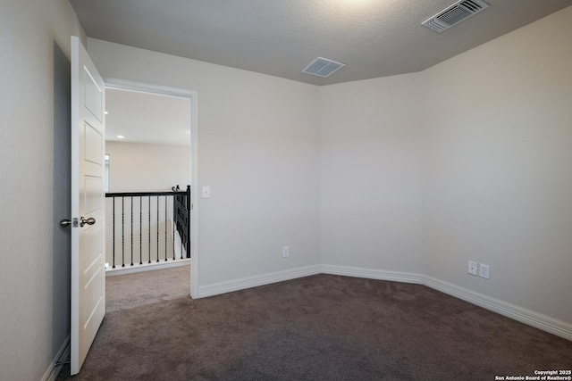 carpeted spare room featuring a textured ceiling