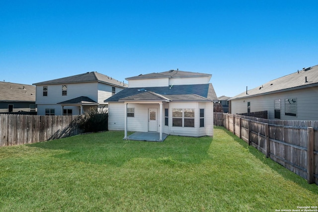 rear view of house with a lawn and a patio