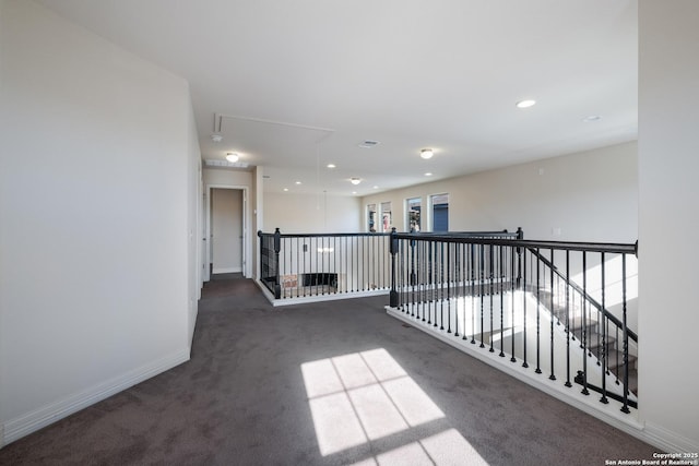 corridor featuring dark colored carpet