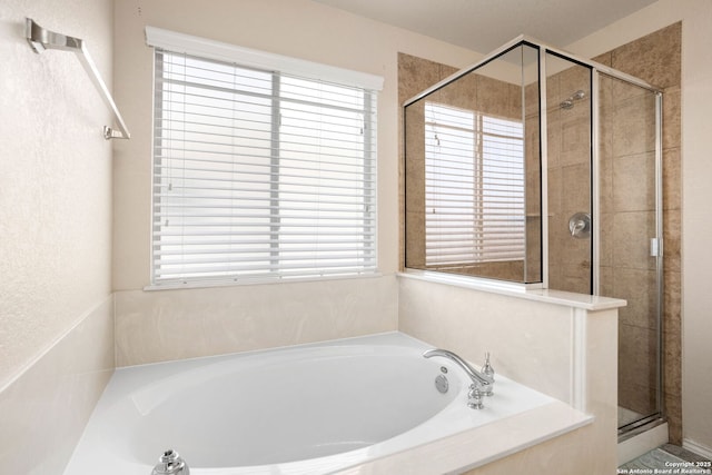 bathroom with plenty of natural light and separate shower and tub