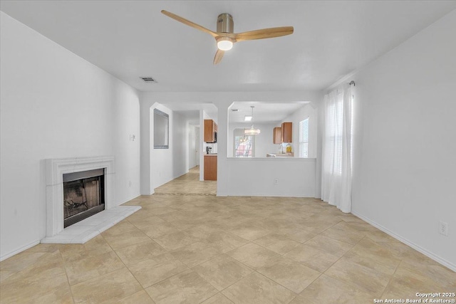 unfurnished living room featuring light tile patterned floors and ceiling fan