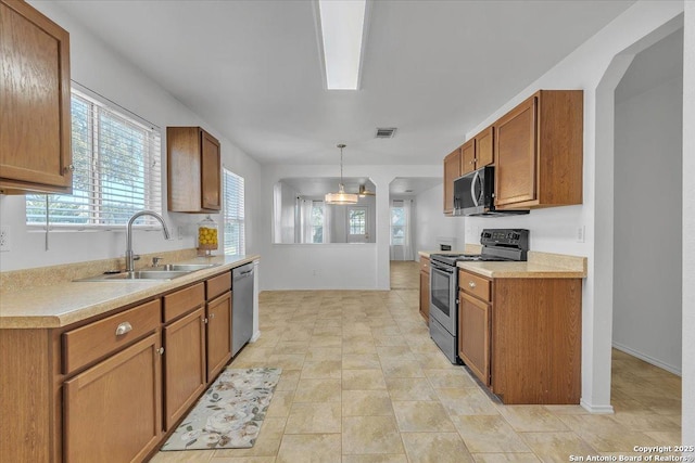 kitchen featuring hanging light fixtures, stainless steel appliances, and sink