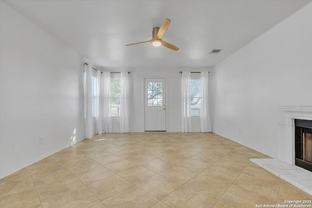 unfurnished living room featuring light tile patterned flooring, plenty of natural light, and ceiling fan