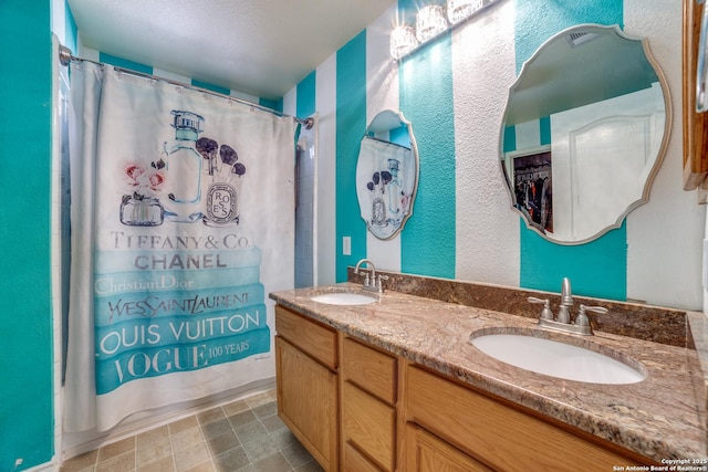 bathroom with shower / tub combo with curtain, vanity, and a textured ceiling