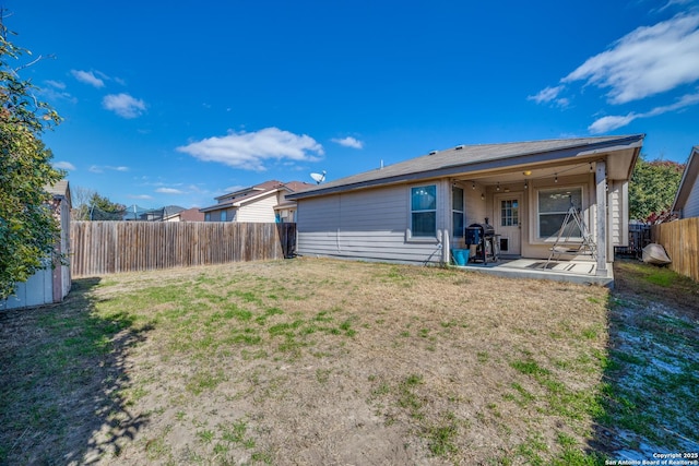 back of house featuring a lawn and a patio