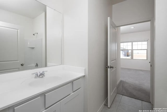 bathroom featuring tile patterned floors, vanity, and a shower