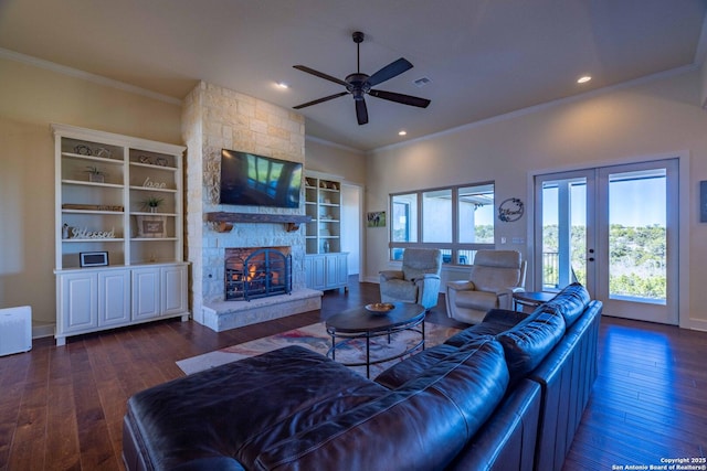 living room with crown molding, dark hardwood / wood-style flooring, a fireplace, and french doors