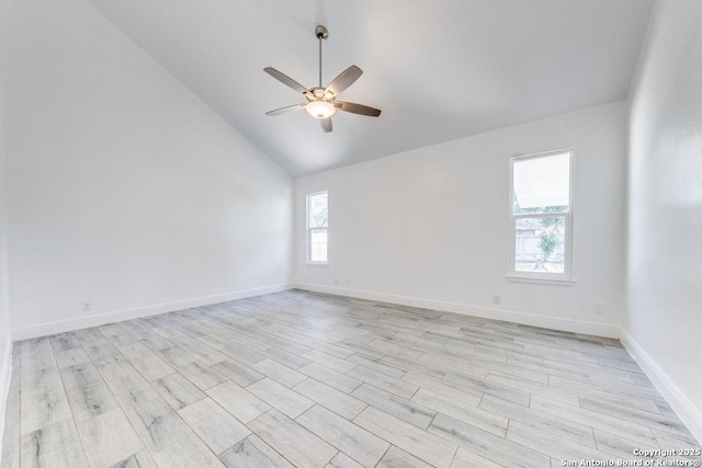 empty room with ceiling fan, lofted ceiling, and light hardwood / wood-style floors