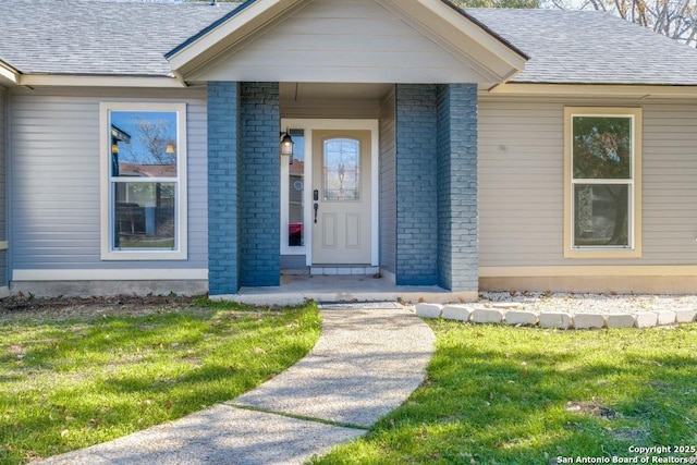 view of exterior entry with a yard