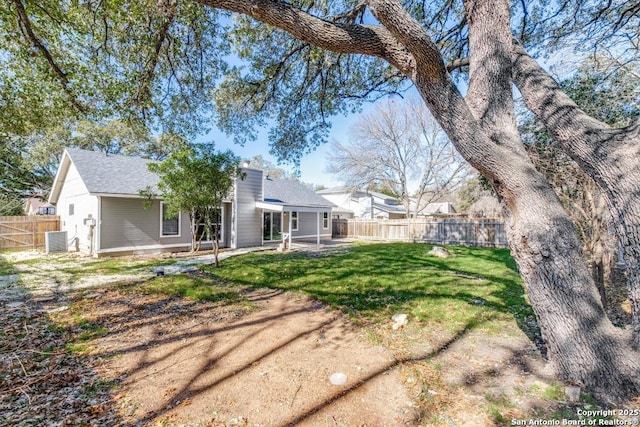 back of house featuring a yard, central AC unit, and a patio area