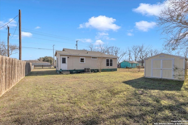 back of house with a storage shed, cooling unit, and a lawn