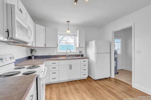 1641 Post Rd, New Braunfels, TX 78130 - kitchen featuring decorative light fixtures, white cabinetry, sink, light hardwood / wood-style floors, and white appliances
