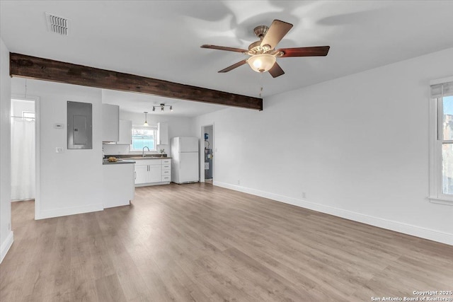 1641 Post Rd, New Braunfels, TX 78130 - unfurnished living room featuring sink, beam ceiling, electric panel, ceiling fan, and light wood-type flooring
