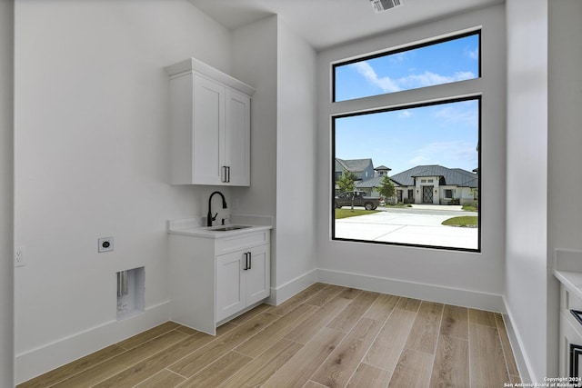 washroom with light hardwood / wood-style flooring, sink, plenty of natural light, and hookup for an electric dryer