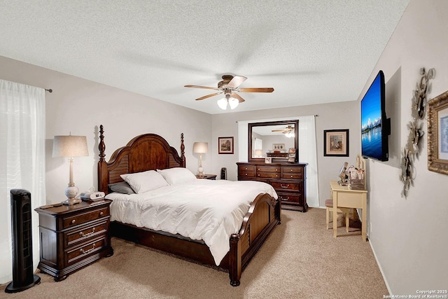 bedroom featuring a textured ceiling, light colored carpet, and ceiling fan