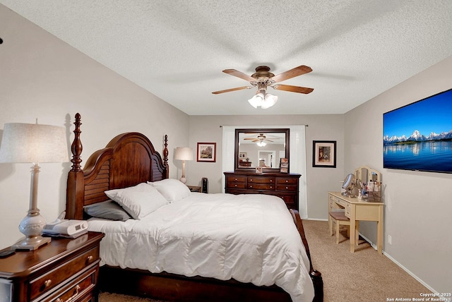 carpeted bedroom featuring ceiling fan and a textured ceiling