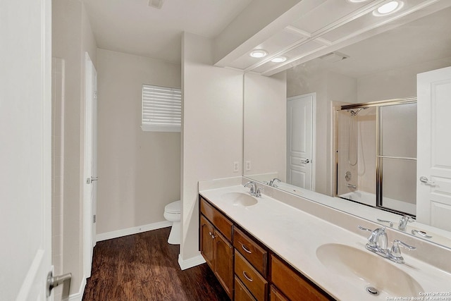 full bathroom with wood-type flooring, vanity, shower / bath combination with glass door, and toilet