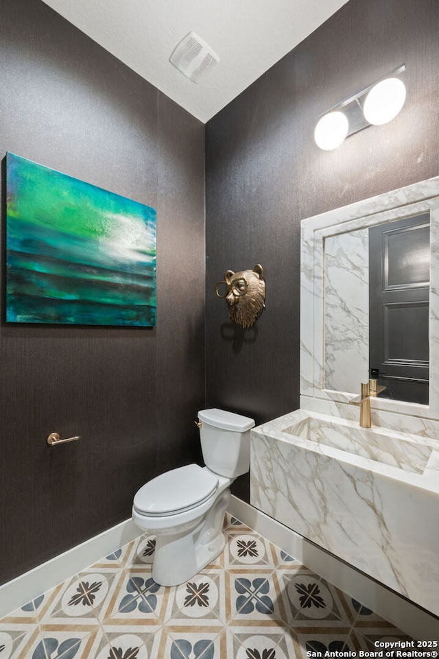 bathroom with toilet, baseboards, and visible vents