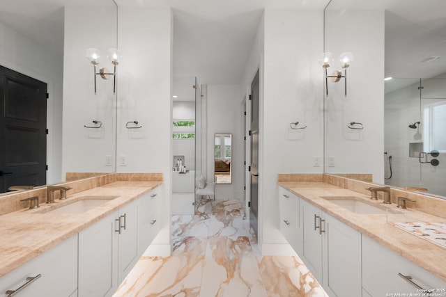 bathroom featuring marble finish floor, two vanities, and a sink