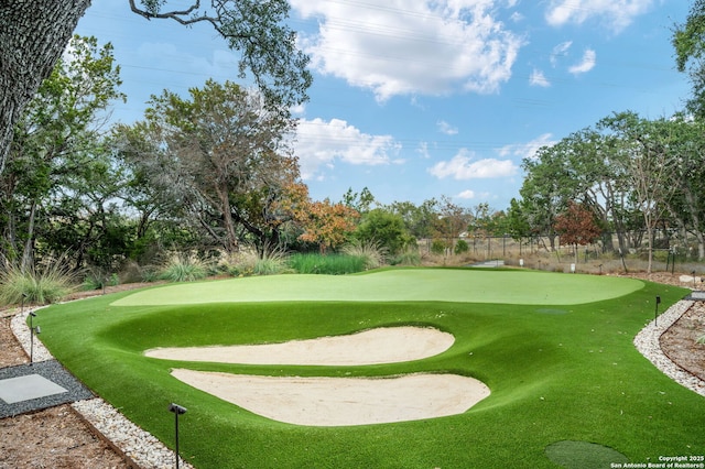 view of property's community with view of golf course and fence