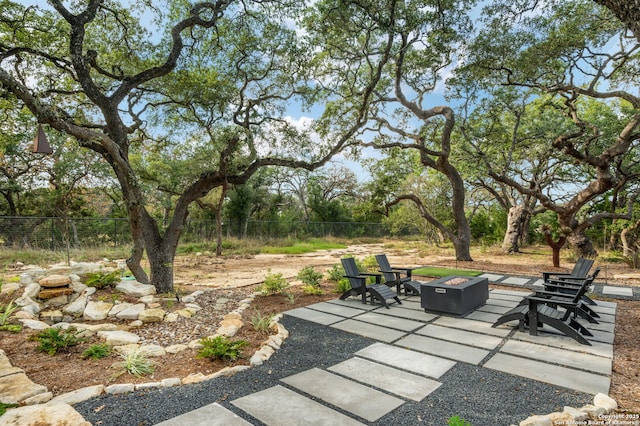 view of patio featuring an outdoor fire pit and fence