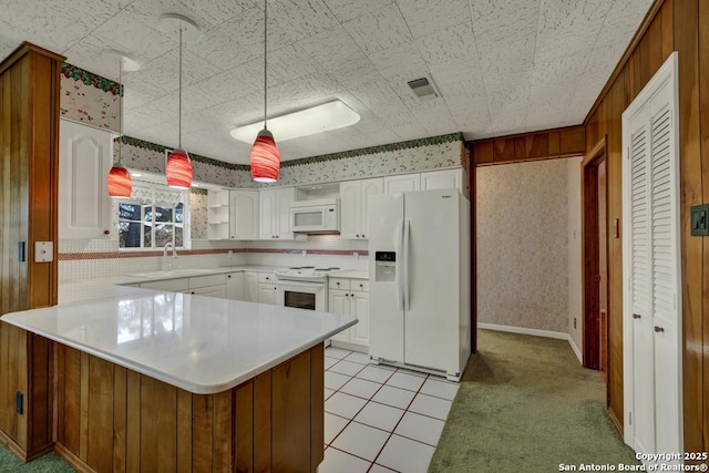 kitchen with pendant lighting, sink, white cabinets, light tile patterned floors, and white appliances