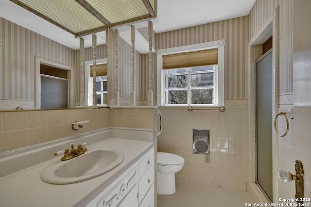 bathroom with vanity, tile walls, an enclosed shower, and toilet