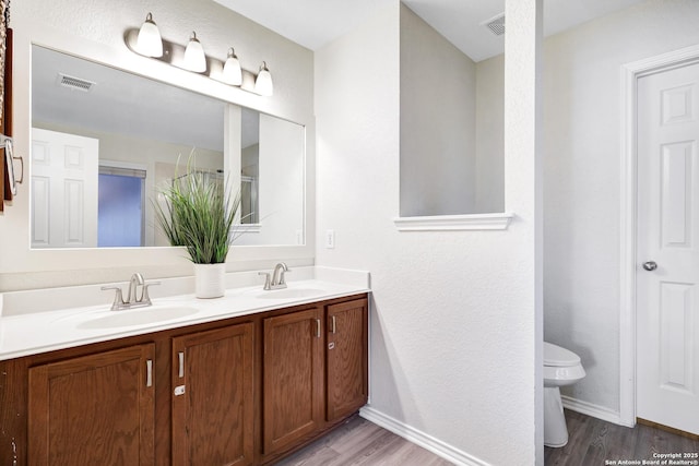 bathroom featuring vanity, wood-type flooring, and toilet