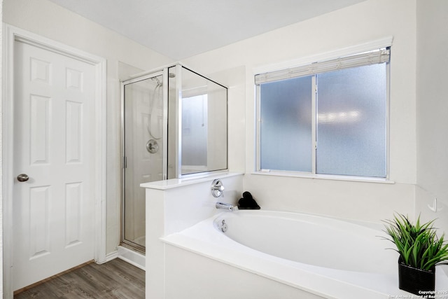 bathroom with hardwood / wood-style flooring, independent shower and bath, and a healthy amount of sunlight