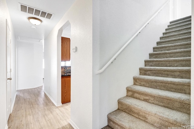 stairs featuring wood-type flooring