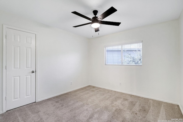 carpeted spare room featuring ceiling fan