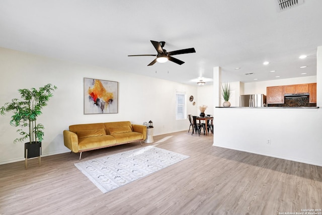 living room featuring ceiling fan and light hardwood / wood-style flooring