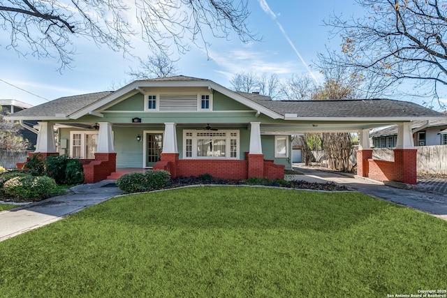 craftsman-style house with ceiling fan, a carport, and a front lawn