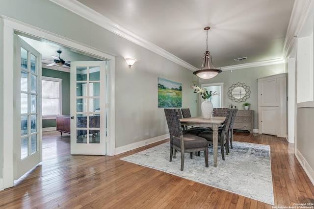 dining space featuring french doors, ornamental molding, and hardwood / wood-style floors