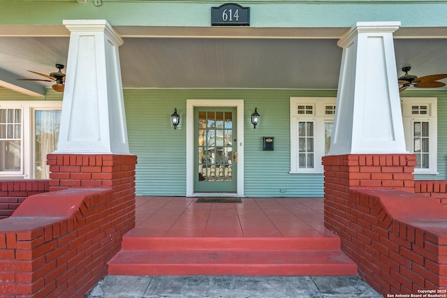 view of exterior entry with ceiling fan and a porch