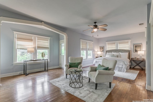 bedroom with hardwood / wood-style flooring, ceiling fan, and multiple windows