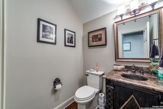 bathroom with hardwood / wood-style flooring, vanity, lofted ceiling, and toilet