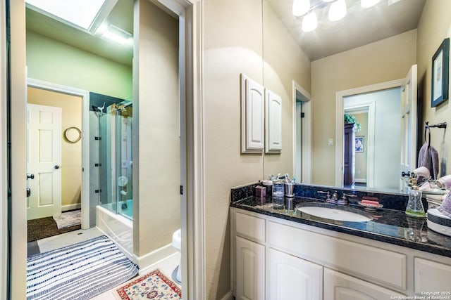 full bathroom with vanity, shower / bath combination with glass door, and toilet