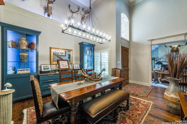 dining space featuring an inviting chandelier, dark hardwood / wood-style floors, crown molding, and a high ceiling