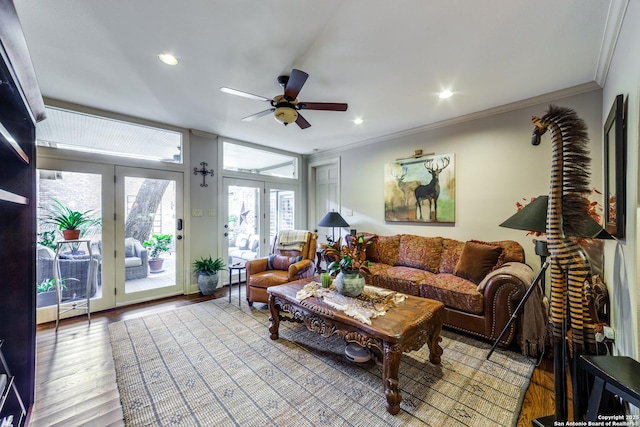 living room featuring ceiling fan, ornamental molding, and wood-type flooring