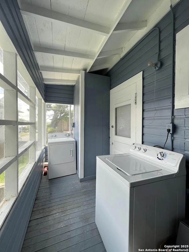 laundry area with dark hardwood / wood-style flooring, wood ceiling, separate washer and dryer, and wood walls