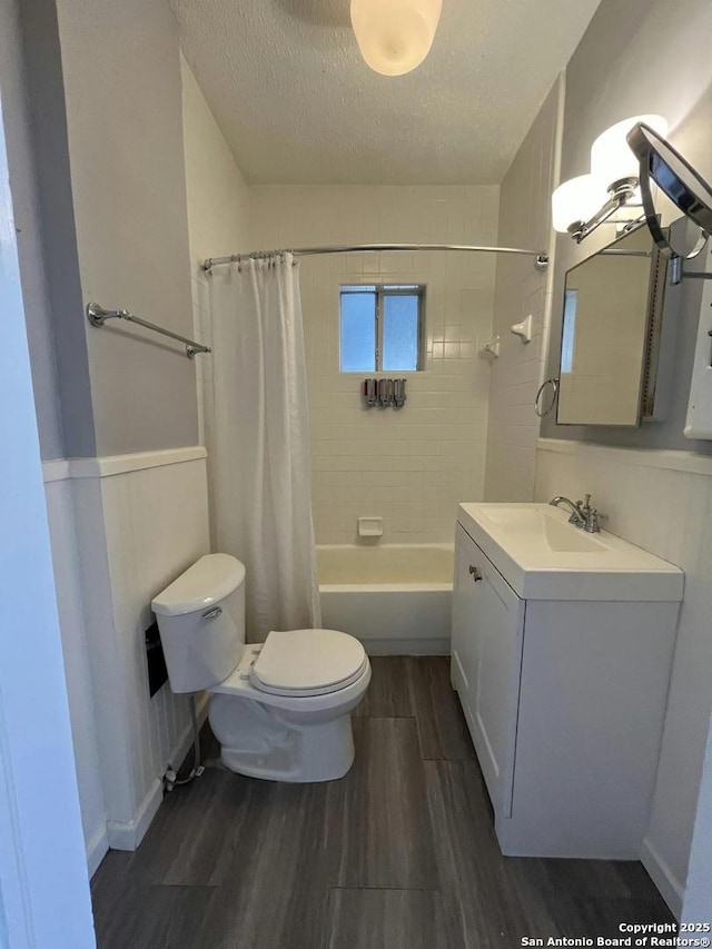 full bathroom featuring hardwood / wood-style floors, shower / tub combo, a textured ceiling, and toilet