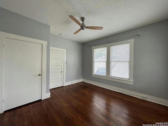 unfurnished bedroom with dark hardwood / wood-style flooring, a textured ceiling, and ceiling fan