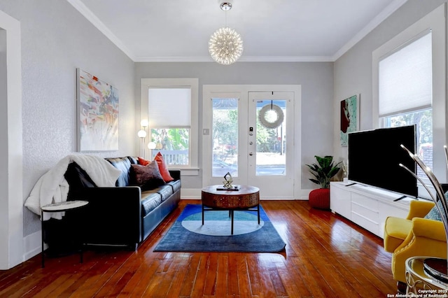 living room featuring dark wood-type flooring, ornamental molding, and a chandelier