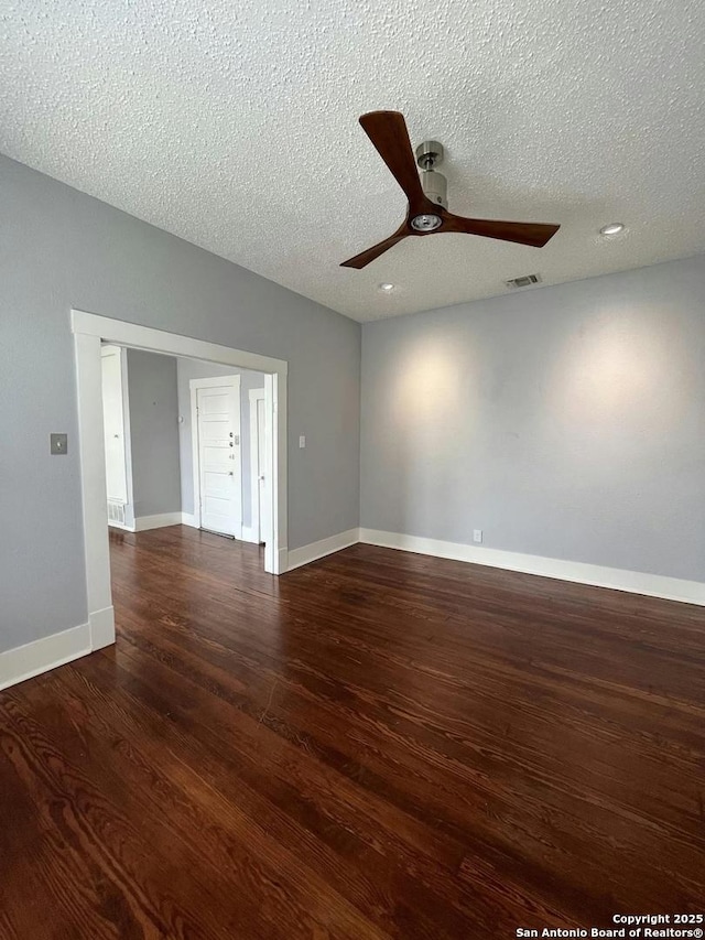 spare room featuring ceiling fan, dark hardwood / wood-style floors, and a textured ceiling