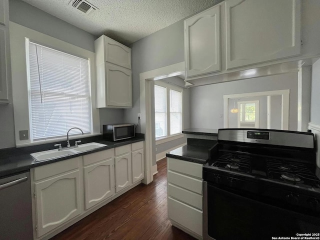 kitchen with stainless steel appliances, sink, and white cabinets