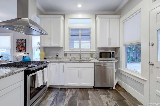 kitchen with white cabinetry, appliances with stainless steel finishes, sink, and exhaust hood