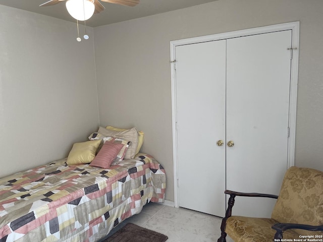 tiled bedroom featuring ceiling fan and a closet