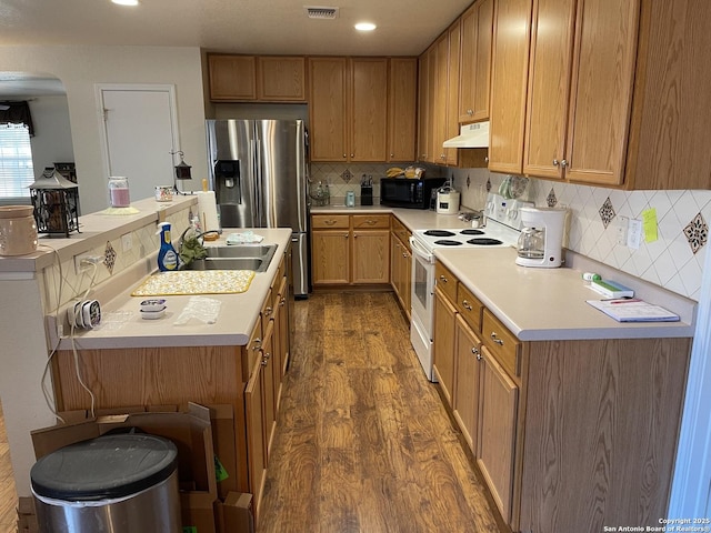 kitchen featuring sink, backsplash, white electric range oven, stainless steel fridge with ice dispenser, and dark wood-type flooring