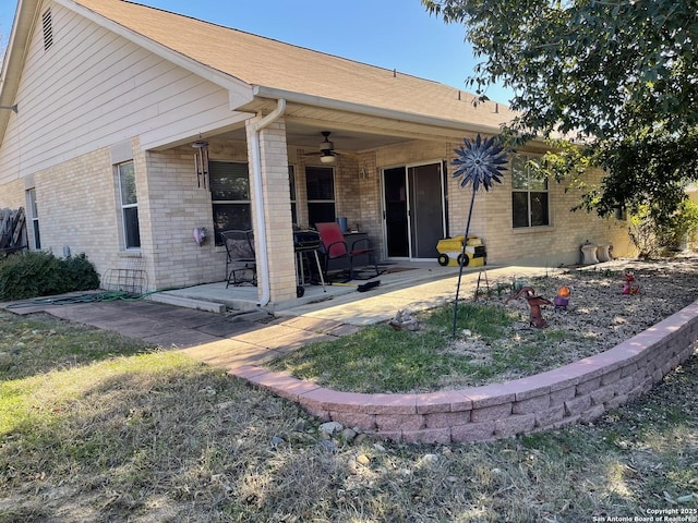 back of property with ceiling fan and a patio